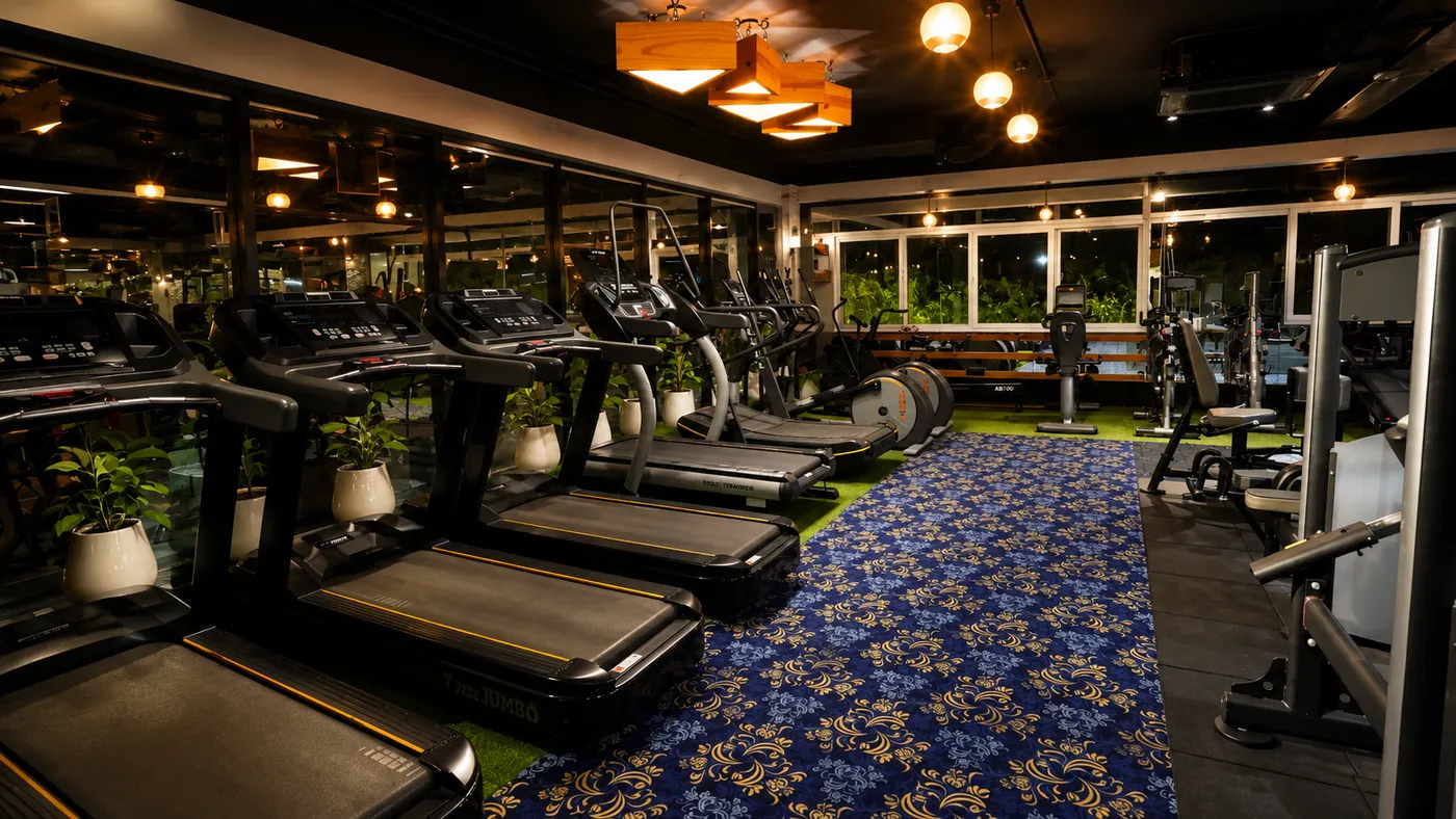 Rows of treadmills behind floor-to-ceiling glass in the cardio zone at V2 Fitness Zone Sainikpuri